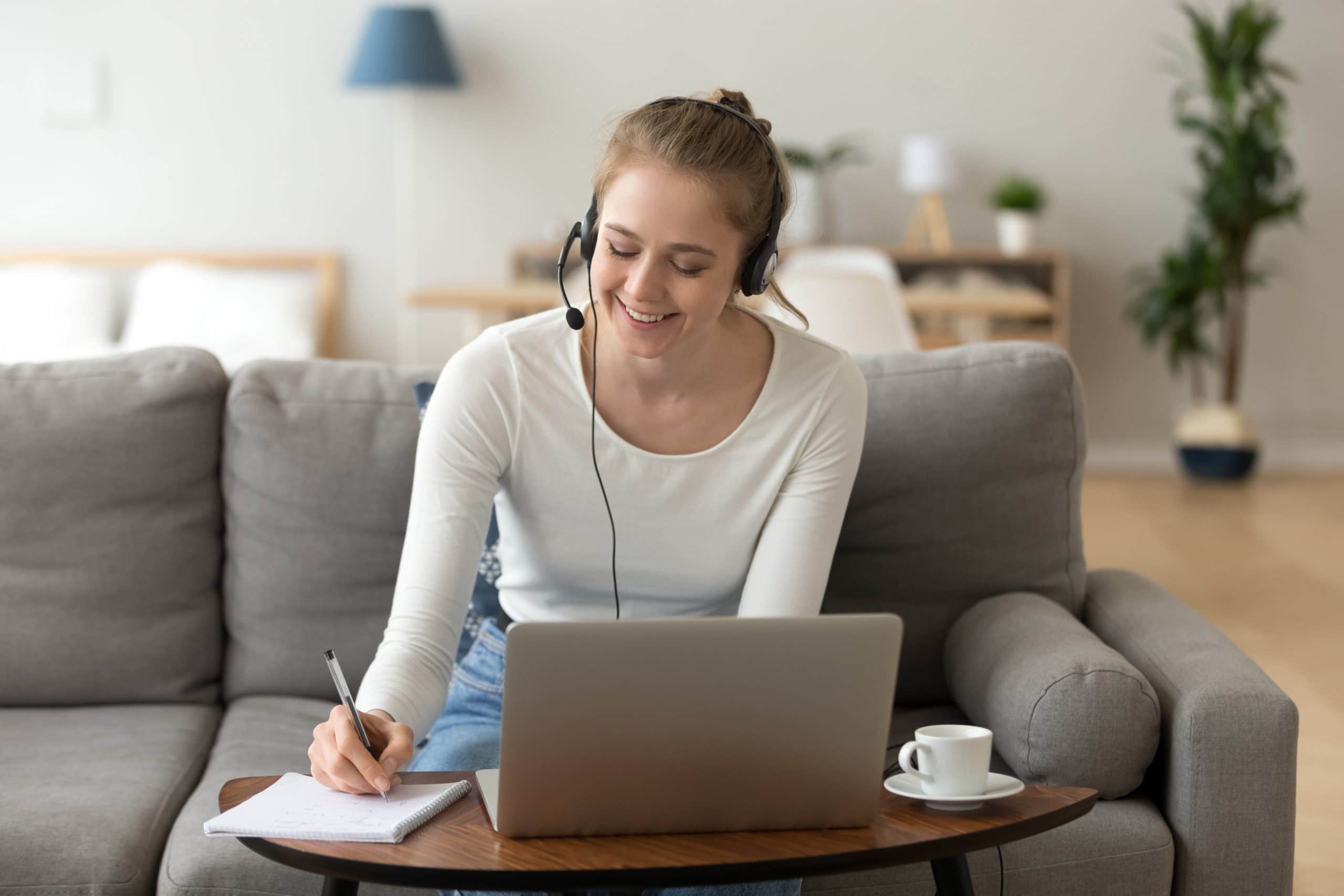 women on customer service call with headset on call, working at computer, taking notes